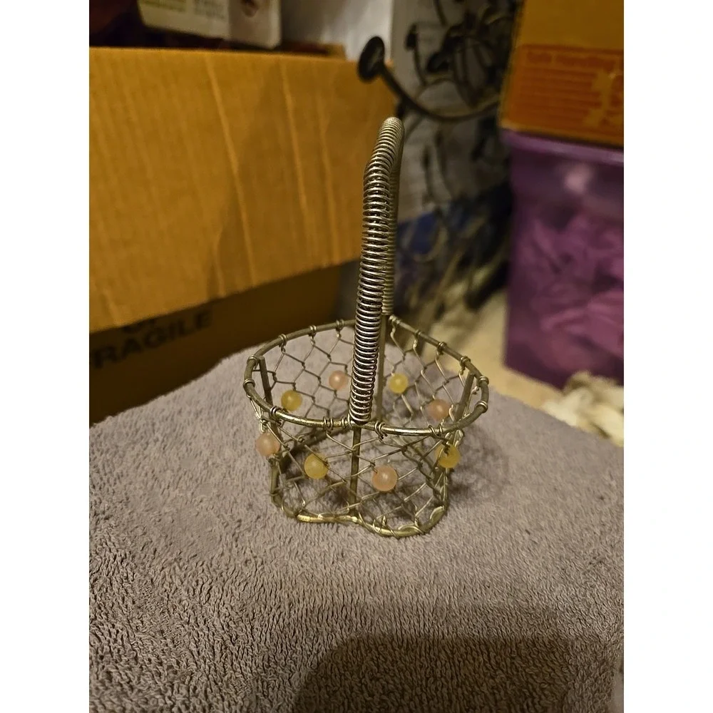 silver-tone wire basket featuring a heart-shaped base and a‎ coiled wire handle